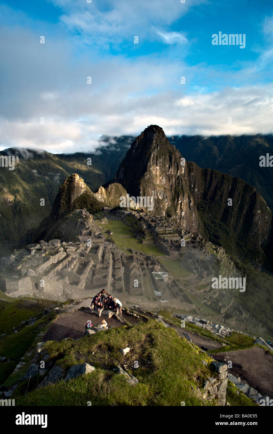 PERU MACHU PICCHU Group poses for photo in front of Machu Picchu at sunrise with Huayna Picchu in the background Stock Photo