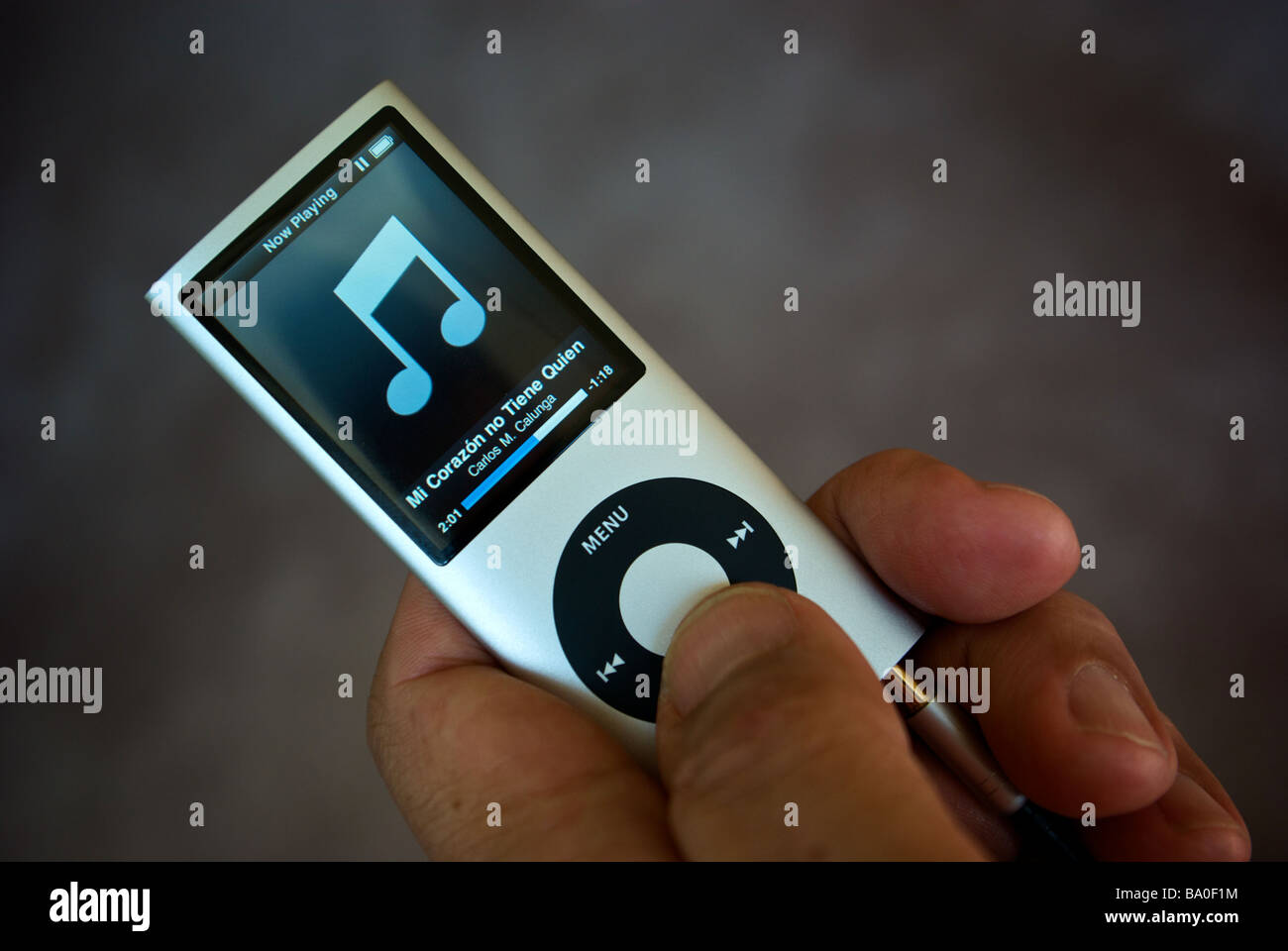 Hand holding and adjusting Apple iPod Nano MP3 portable personal stereo player Stock Photo