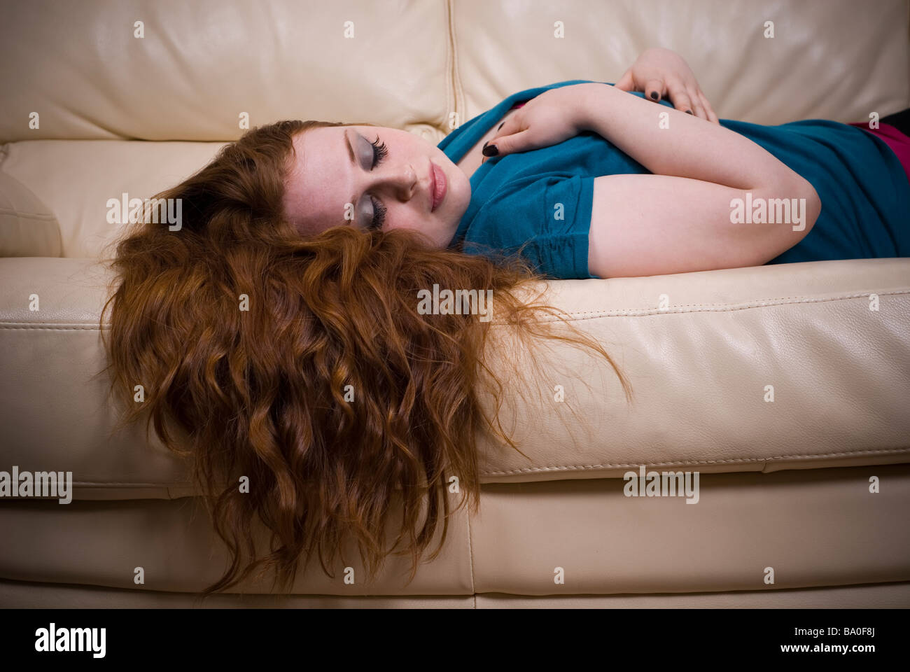 Young woman lying on sofa with eyes closed Stock Photo - Alamy