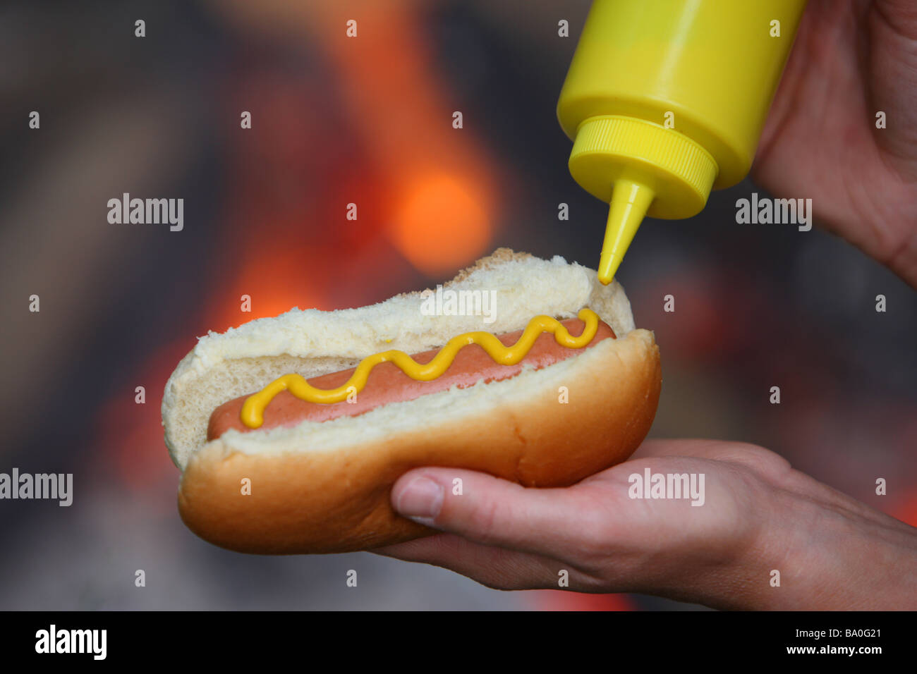 Putting mustard on hot dog by campfire Stock Photo Alamy