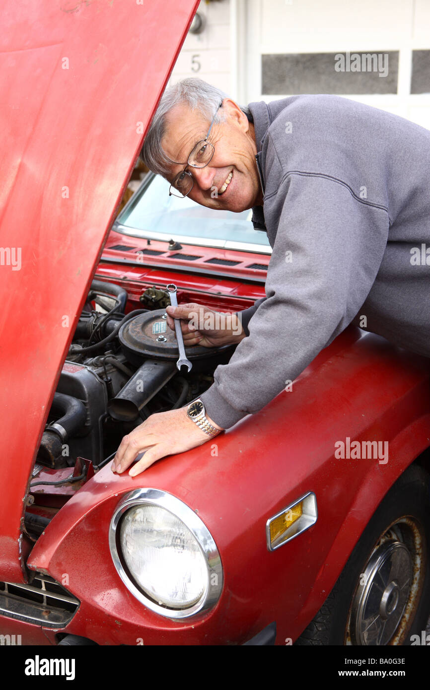 Senior man working on classic car Stock Photo