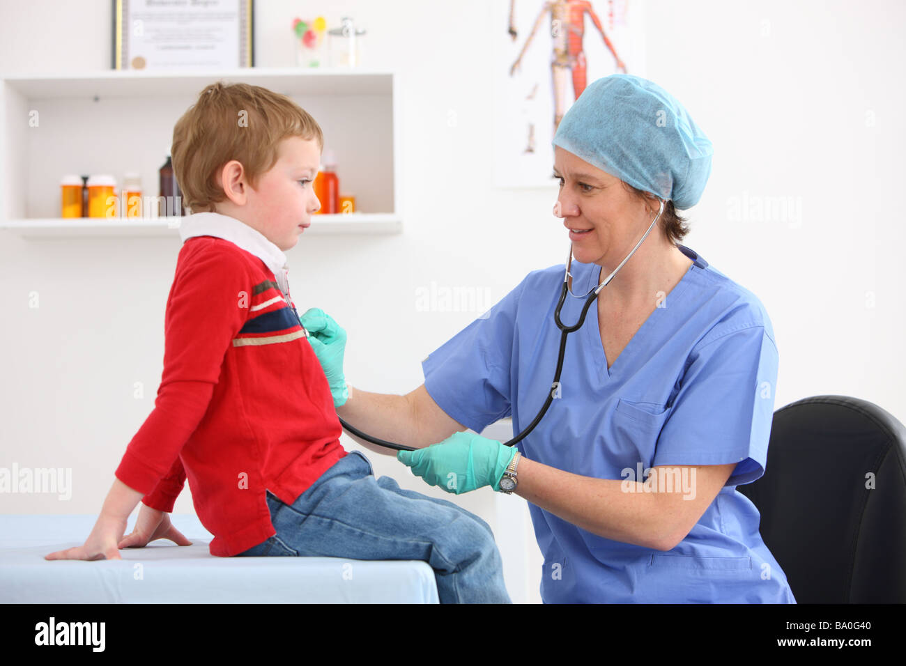 Pediatrician checking young boy s heart with stethoscope Stock Photo