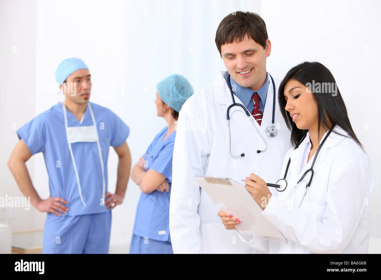 Medical personnel focus on people in foreground Stock Photo