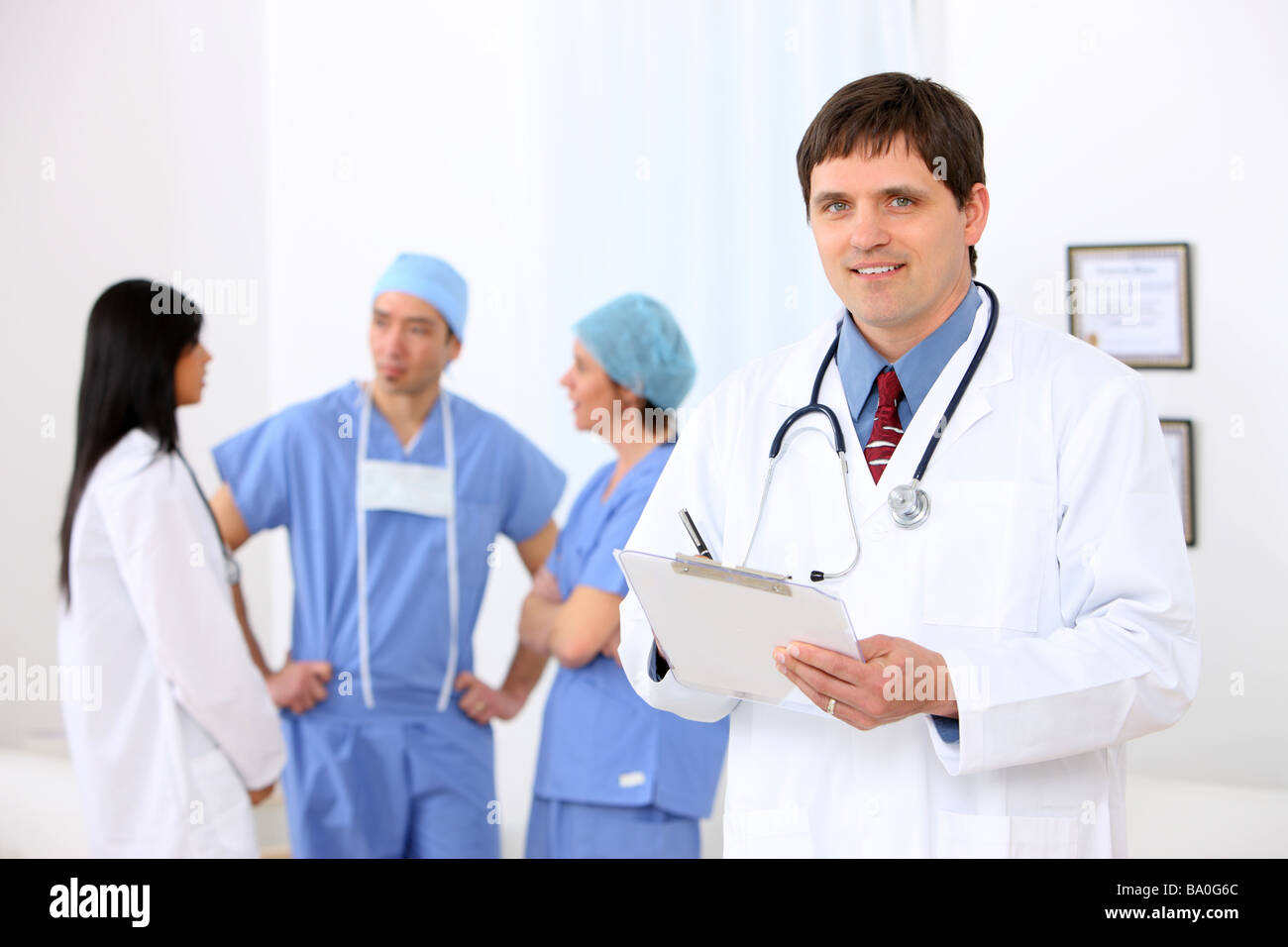 Doctor portrait with medical personnel in background Stock Photo