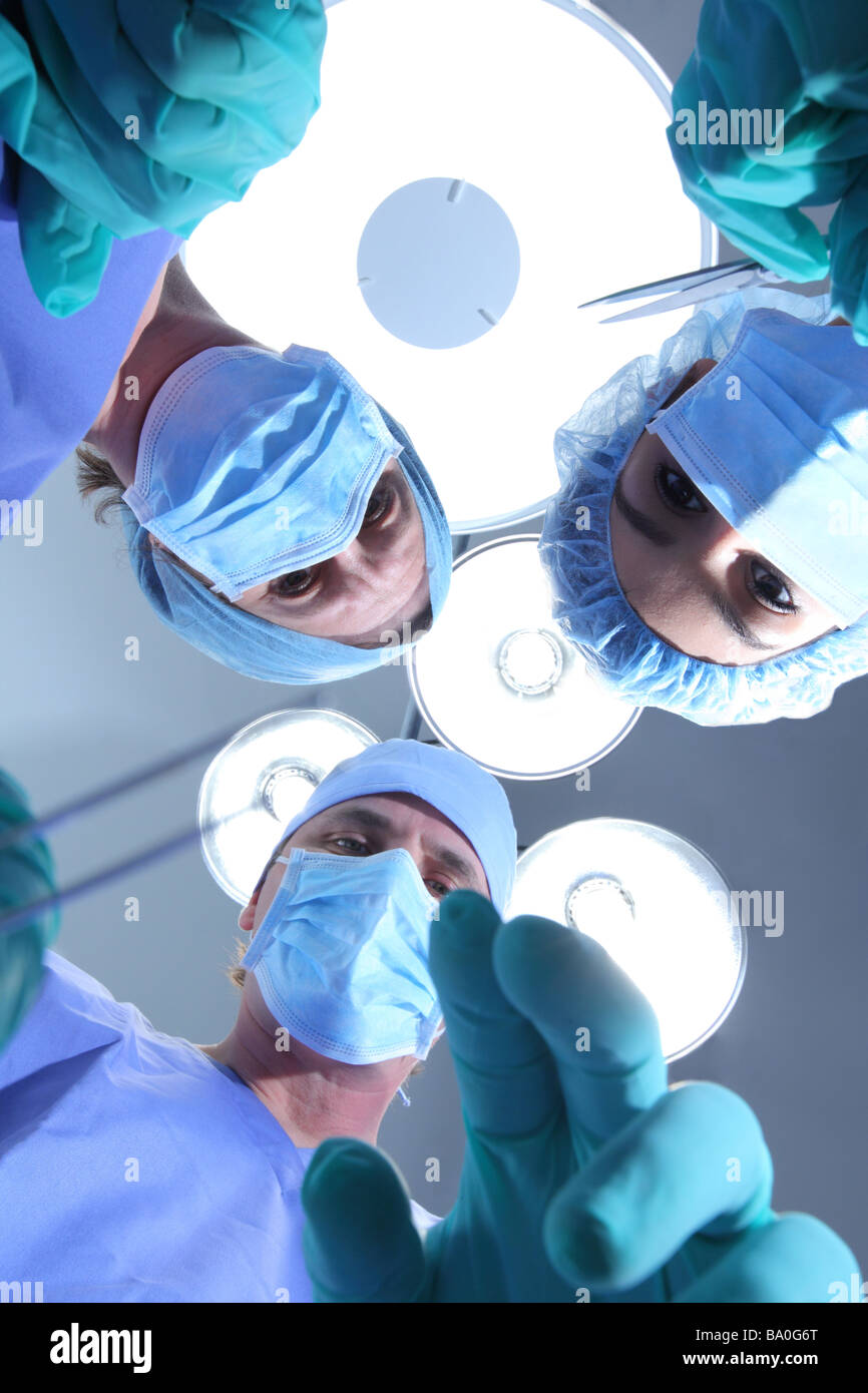 Group of surgeons looking down at patient Stock Photo