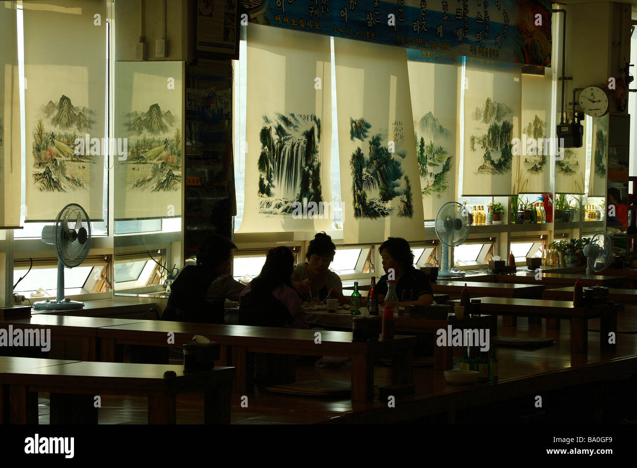 Korean seafood restaurant located in the fish market building with decorated painted windows drapes serving customers. Stock Photo