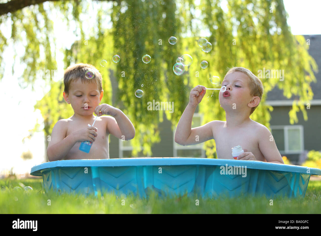 Two young boys in pool blowing bubbles Stock Photo Alamy
