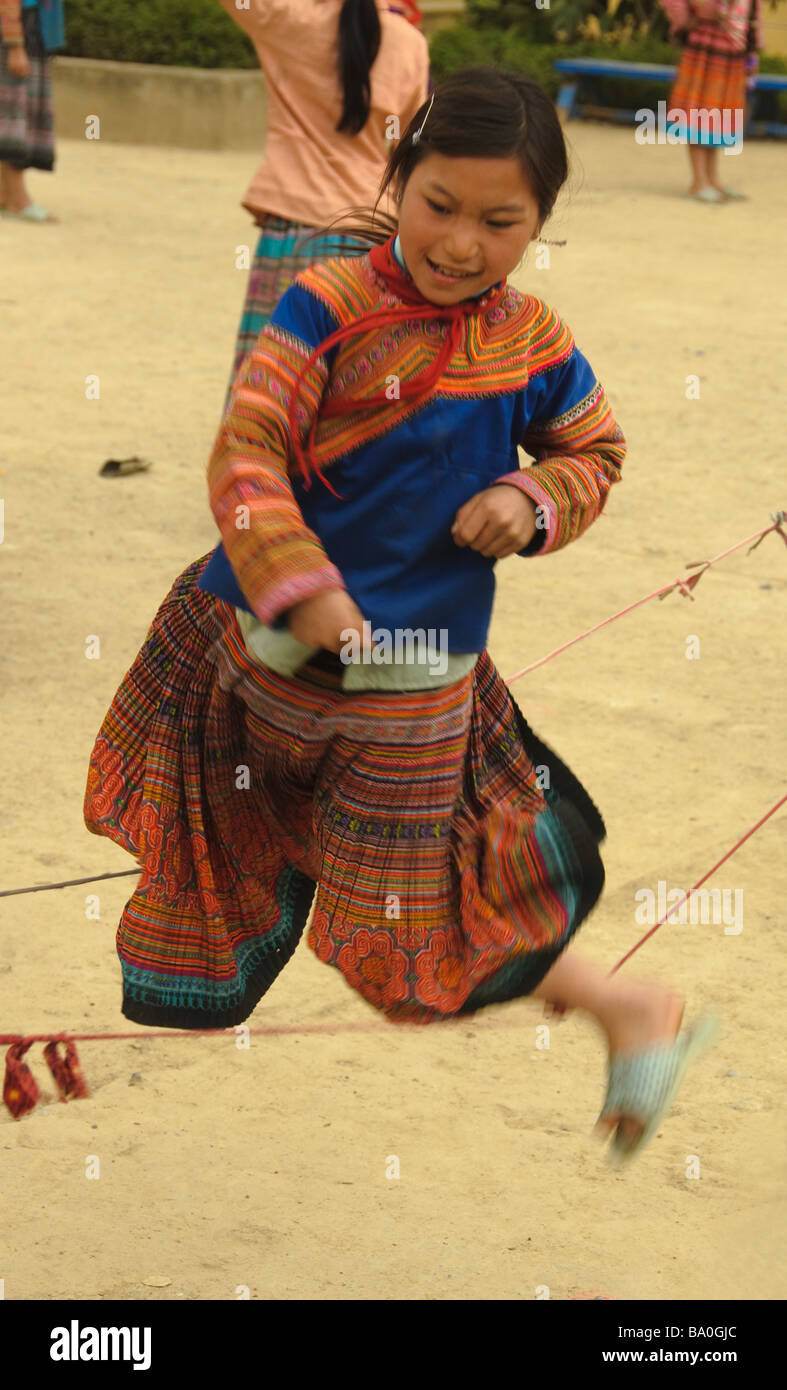 Flower Hmong schoolgirl playing in Cau Son near Bac Ha Vietnam Stock Photo