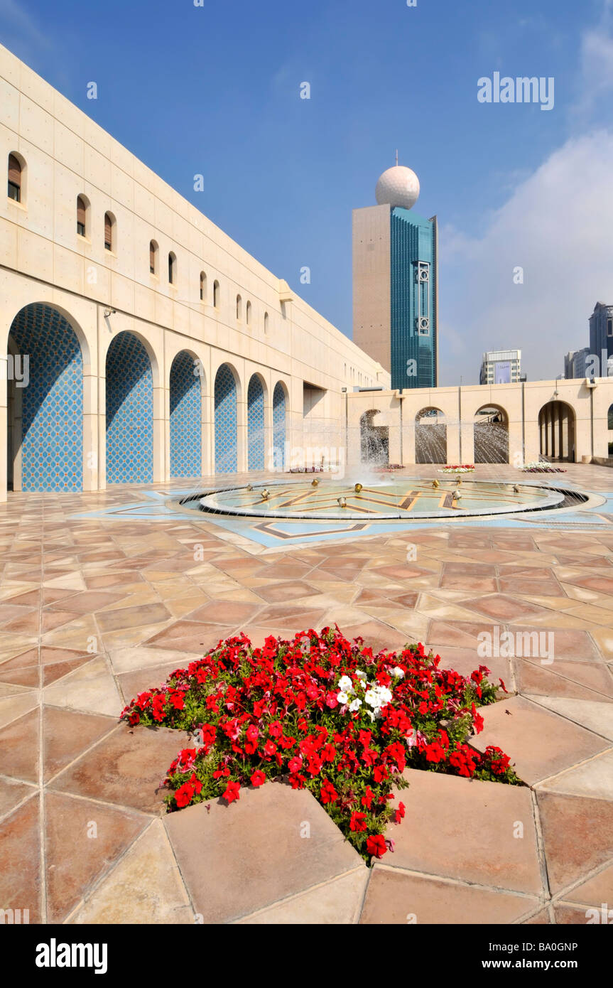 Abu Dhabi Cultural Foundation paved courtyard and fountain with red petunia flowers Stock Photo