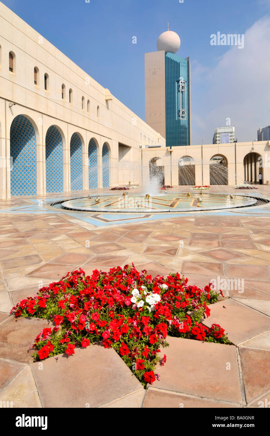 Abu Dhabi Cultural Foundation paved courtyard and fountain with red petunia flowers Stock Photo