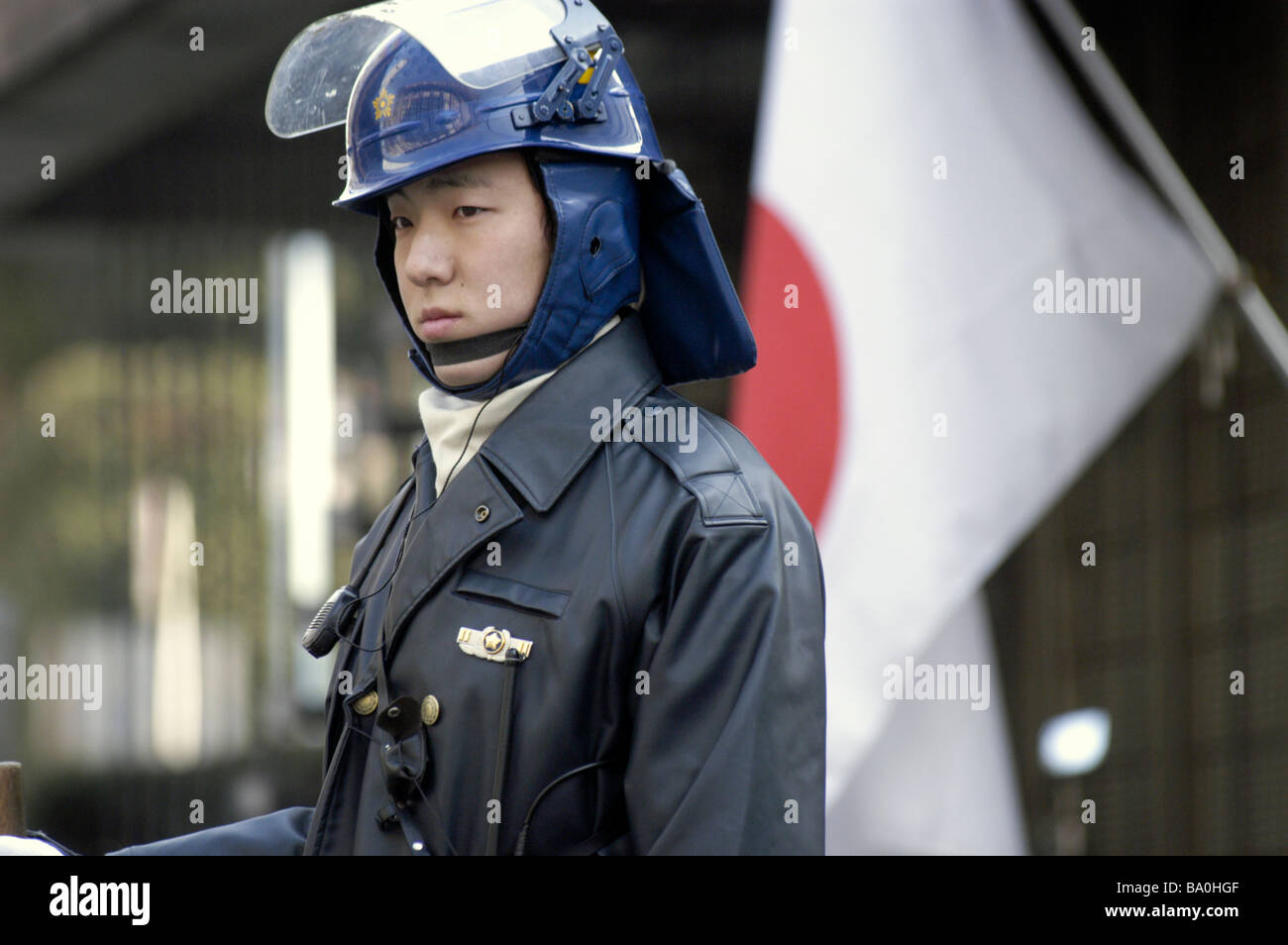 A Japanese policeman in riot gear stands guard outside the US embassy in Tokyo Japan Stock Photo