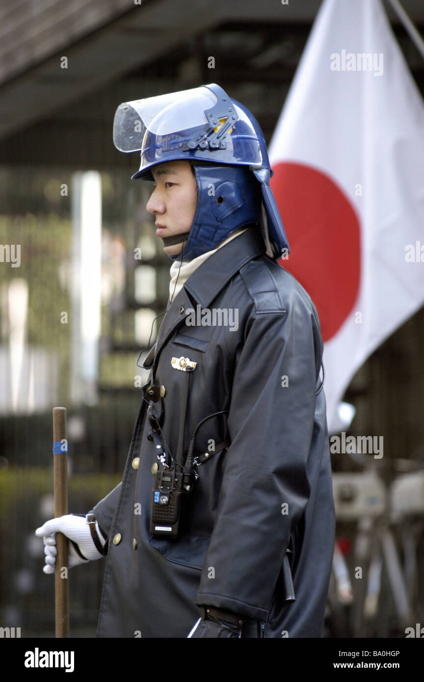 A Japanese policeman in riot gear stands guard outside the US embassy in Tokyo Japan Stock Photo