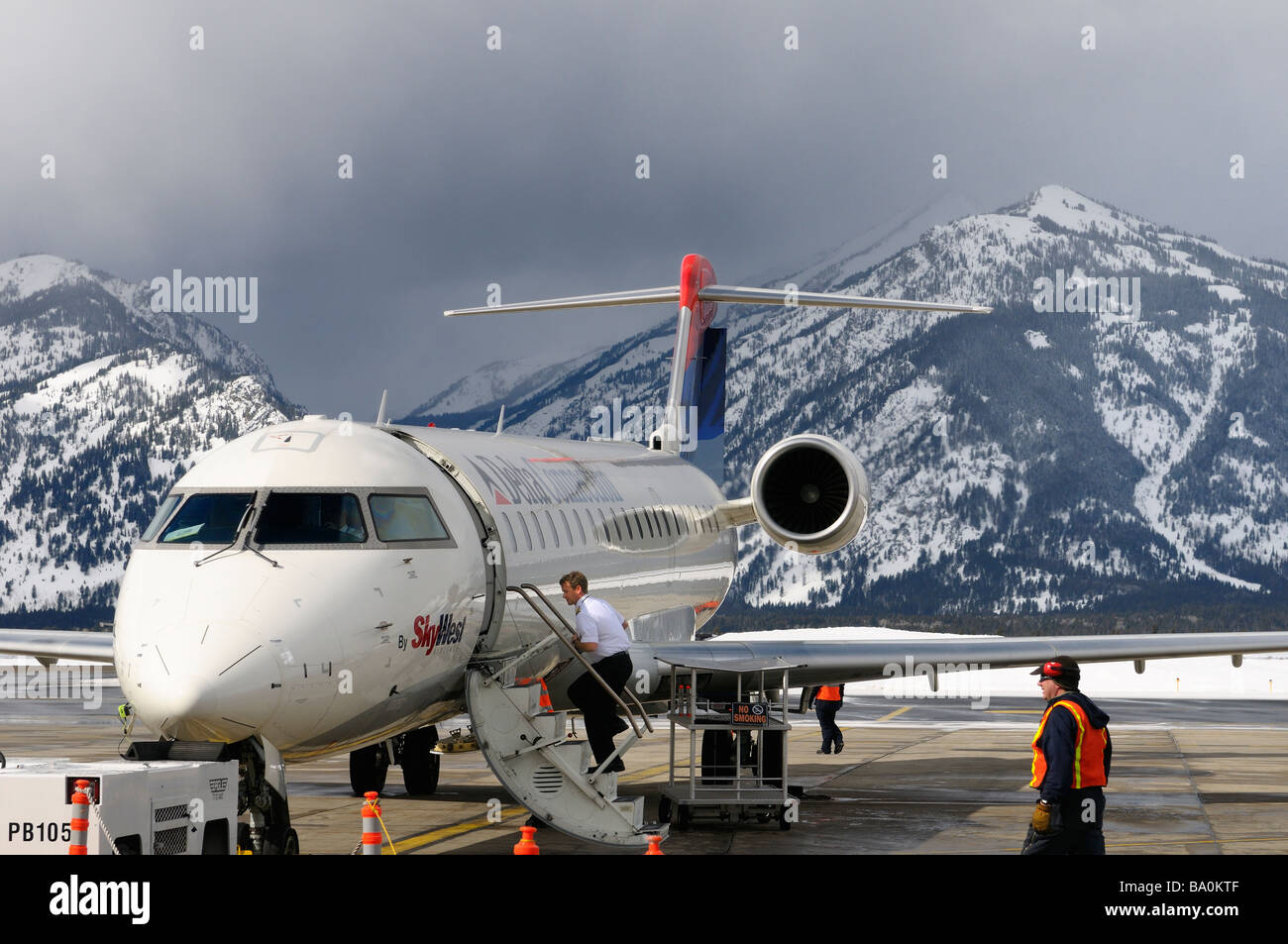 Clouds over Apres Vous Peak Granite Canyon and Mount Hunt of the Teton Range from Jackson Hole Wyoming Airport with jet Stock Photo