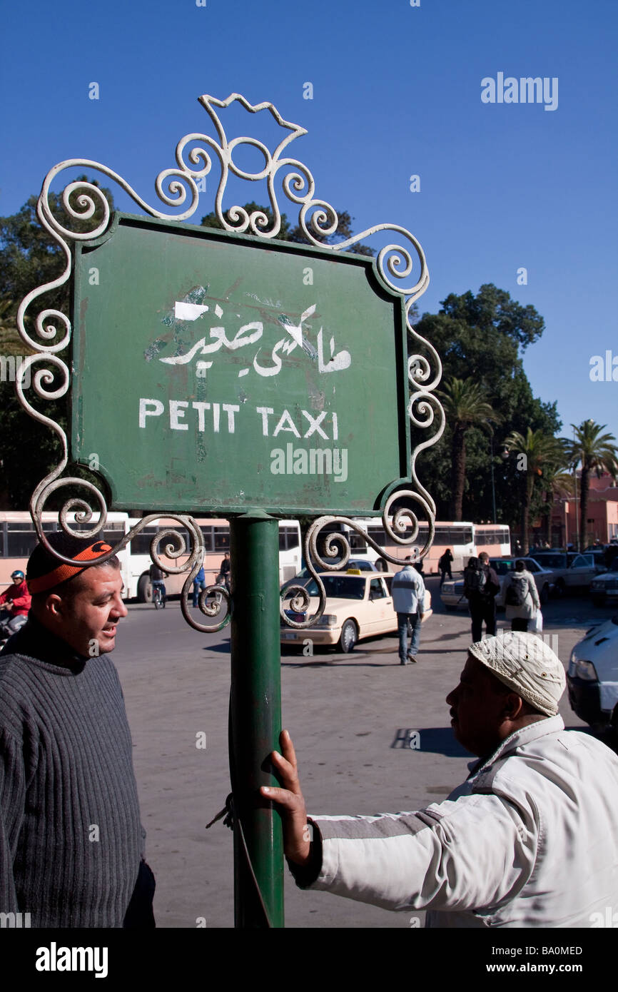 Taxi drivers wait for custom by a 'petit taxi' sign at a taxi rank near the place Jemaa El Fna in the Medina, Marrakech Stock Photo