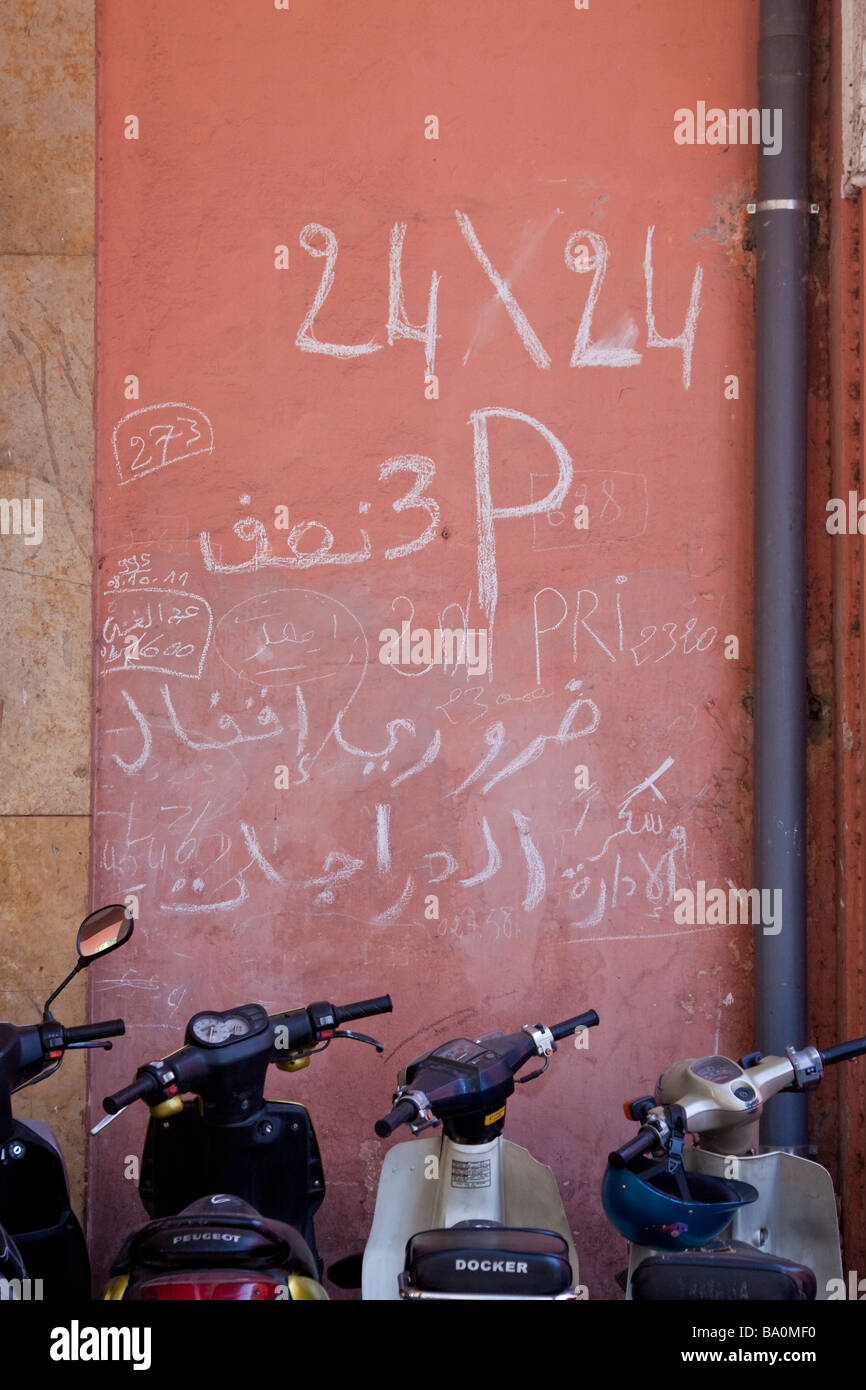 Motorcycle scooter seen infront of a colourful traditionally patterned wall near the place Jemaa El Fna in Marrakech Morocco Stock Photo