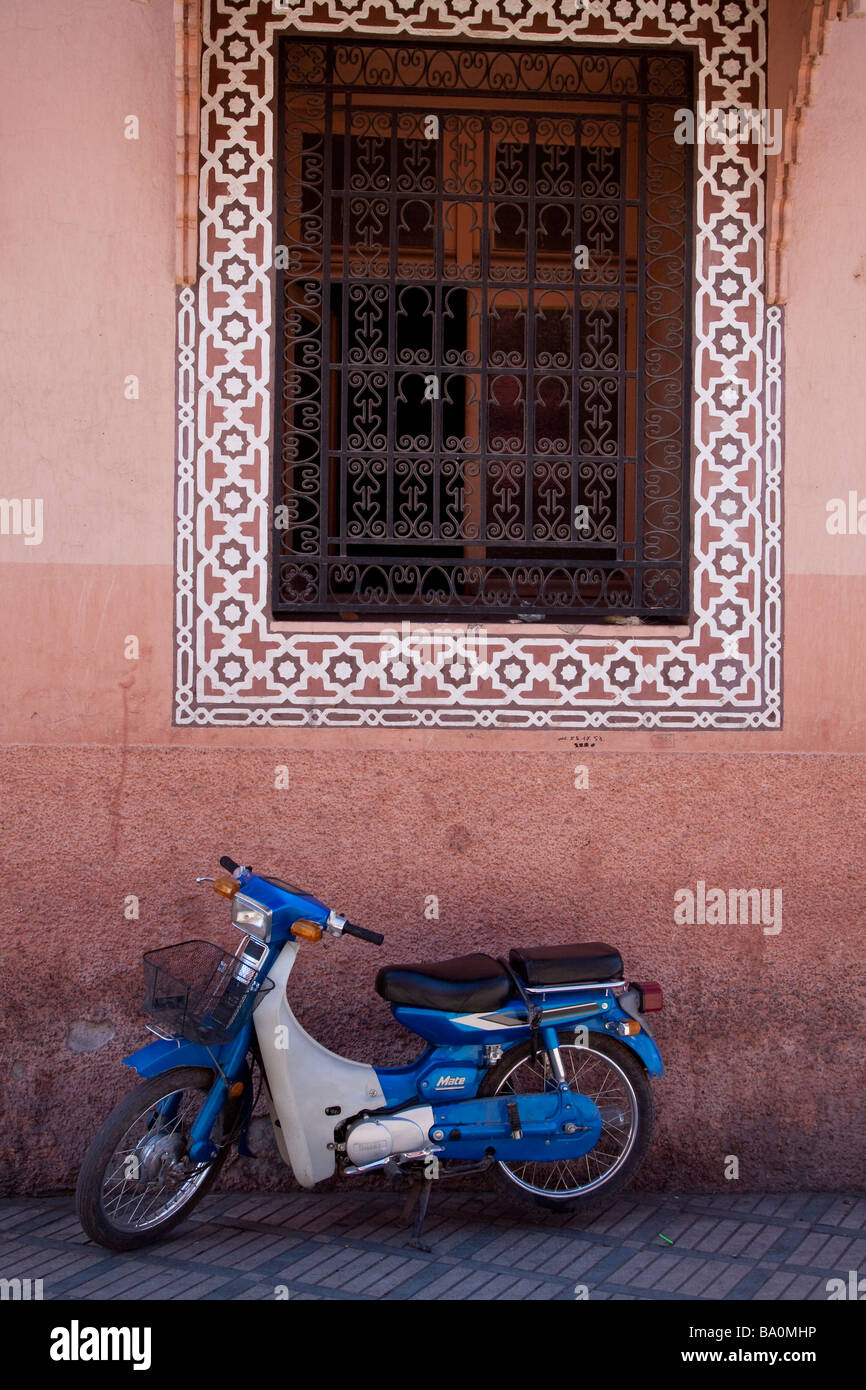 Motorcycle scooter seen infront of a colourful traditionally patterned wall near the place Jemaa El Fna in Marrakech Morocco Stock Photo