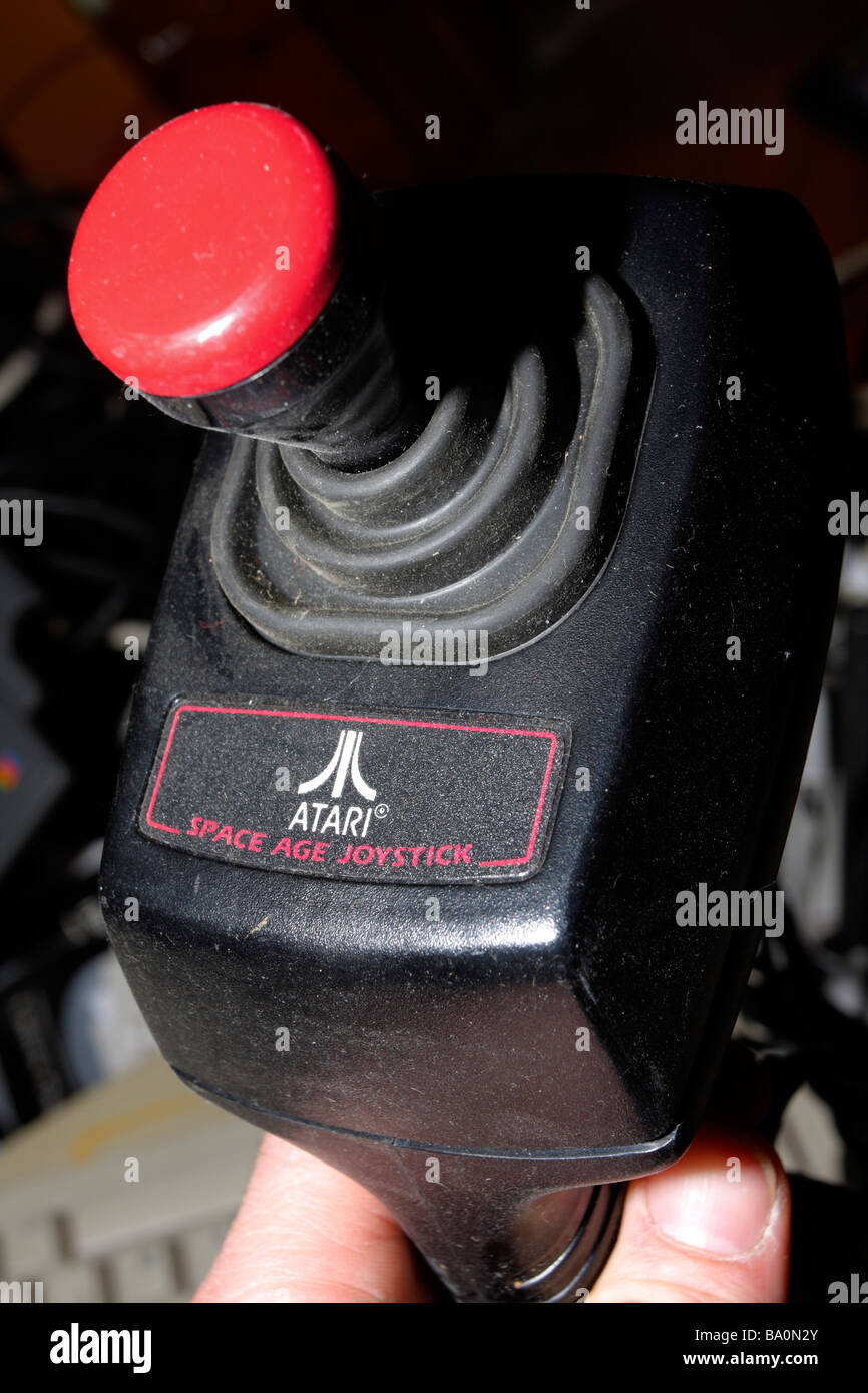 Black plastic Atari joystick controller in hand showing knob. Stock Photo