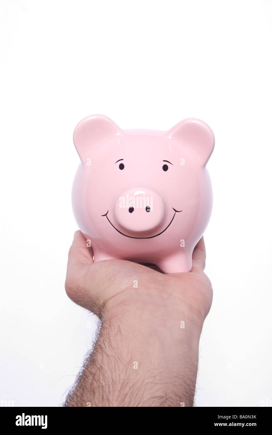 Hand holding a pink piggy bank against a white background Stock Photo