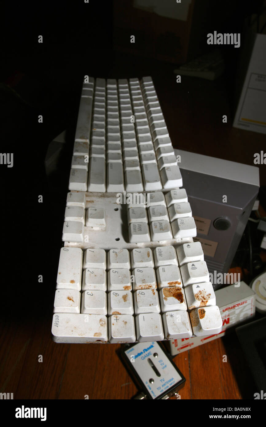 Damaged white plastic mac Apple keyboard with orange substance spilled