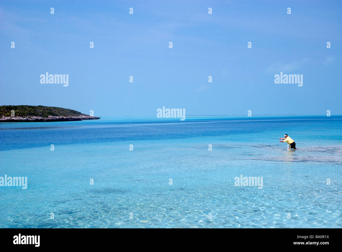 a fly fisherman casts to bonefish in the flats of the exuma islands, bahamas Stock Photo
