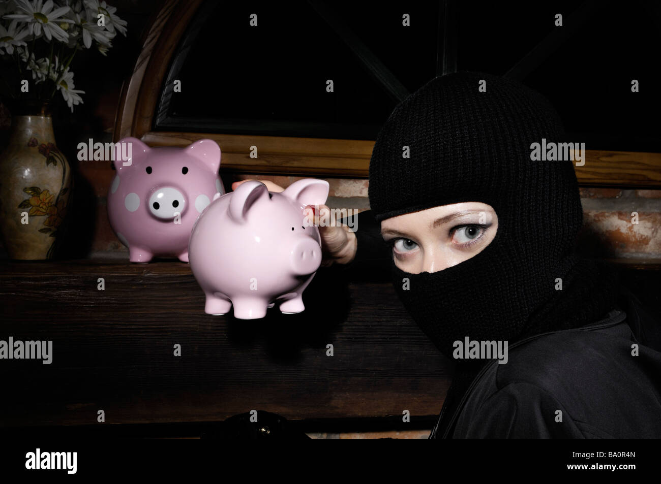 Burglar stealing piggy banks Stock Photo