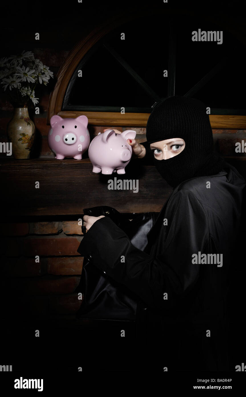 Burglar stealing piggy banks Stock Photo