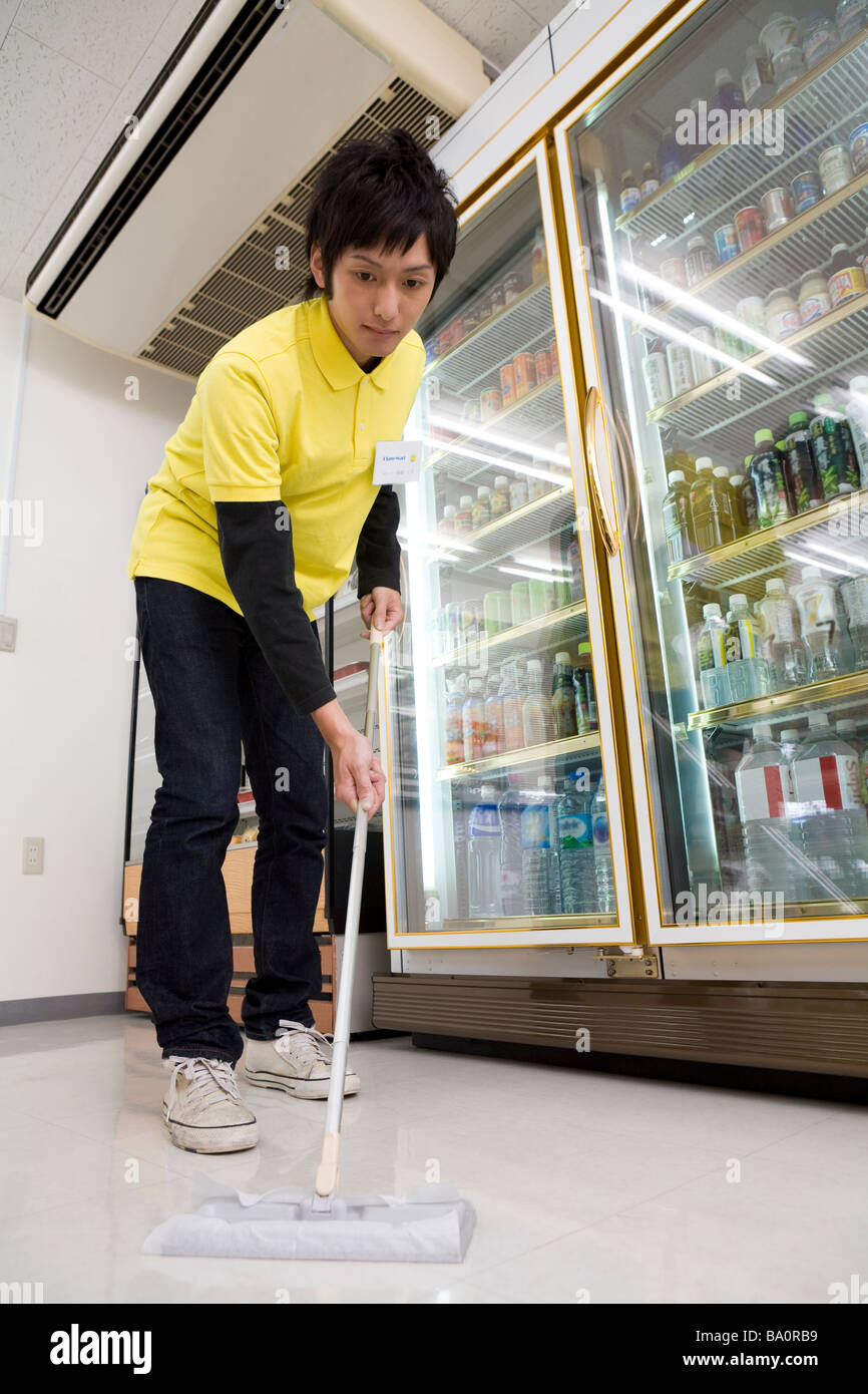 Convenience store clerk cleaning up store Stock Photo Alamy