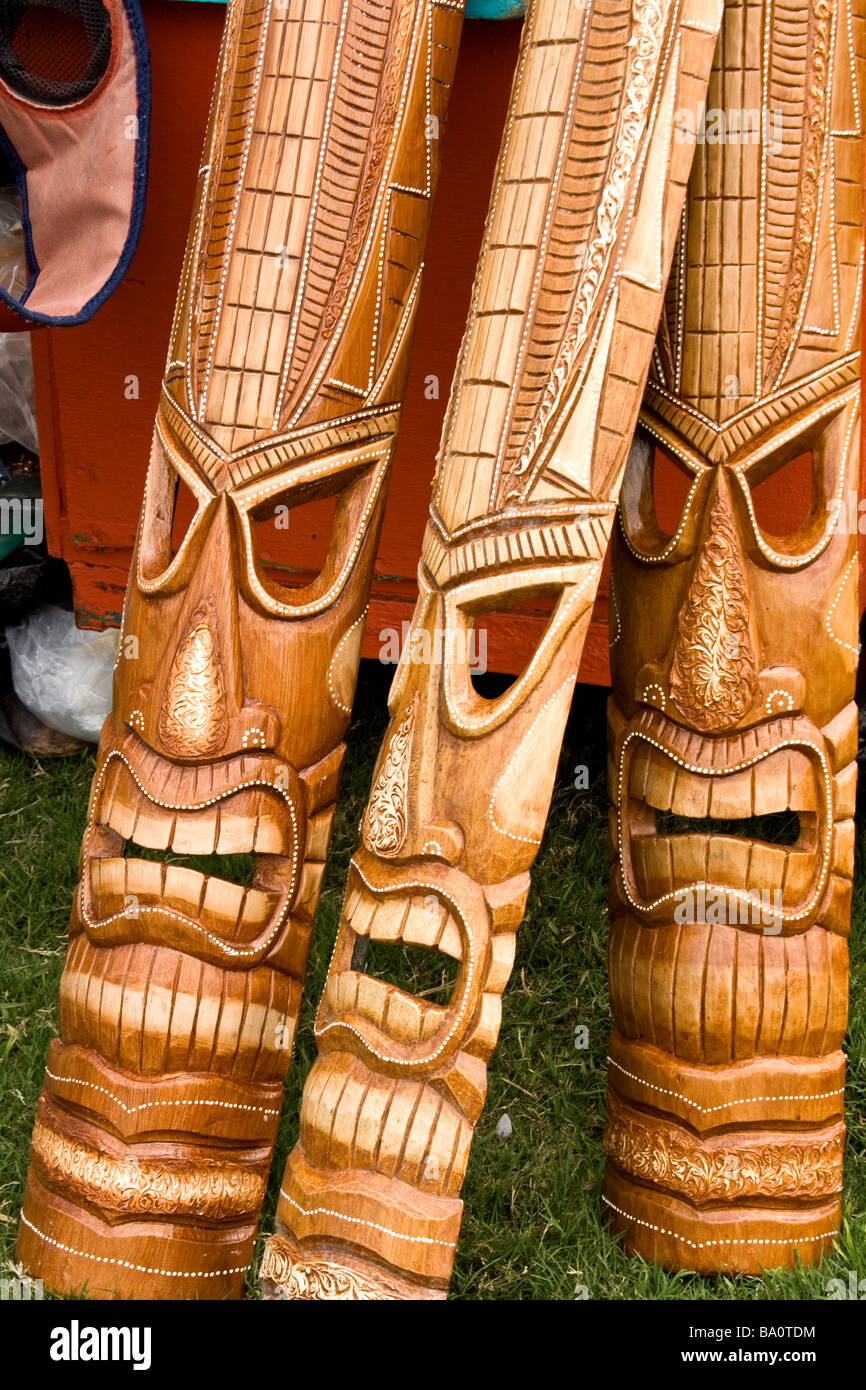 Three wooden instruments with faces carved into them. Stock Photo