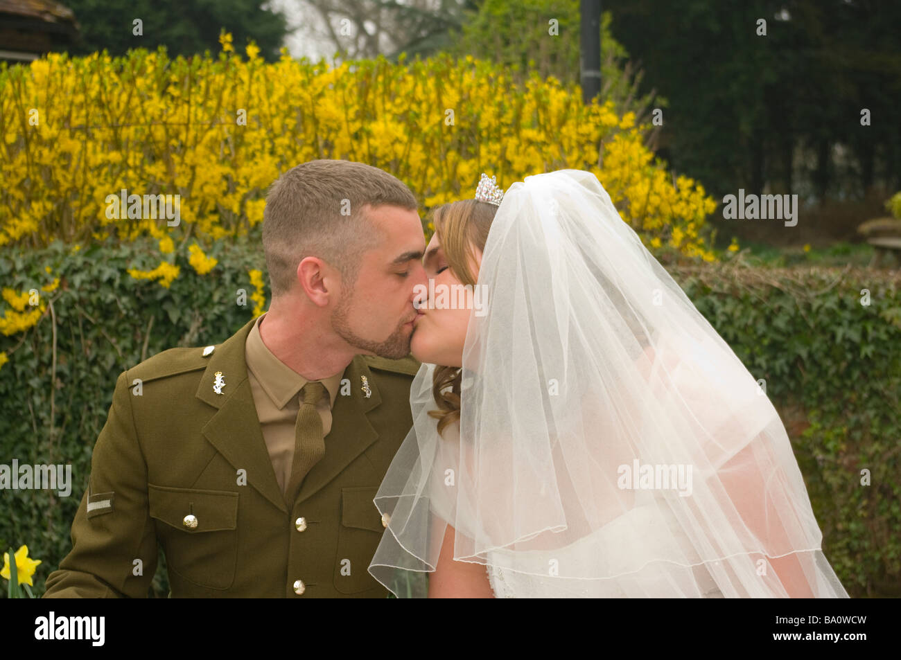 Bride and Groom in Army Uniform Kissing military armed forces wedding Stock Photo