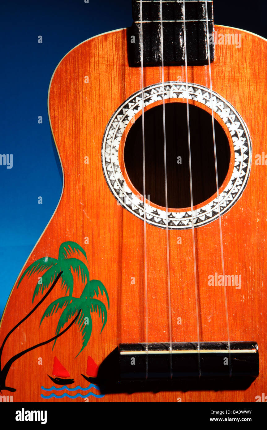 Ukulele from Cook islands with painted palm trees and blue background Stock Photo