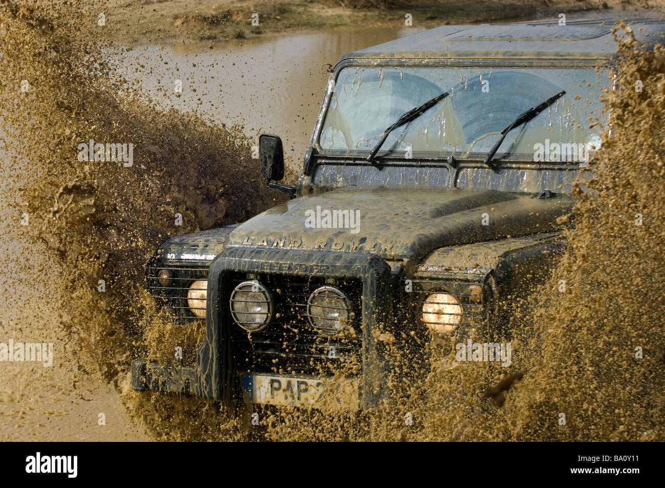 A Land Rover Defender 90 driving through a flood Stock Photo