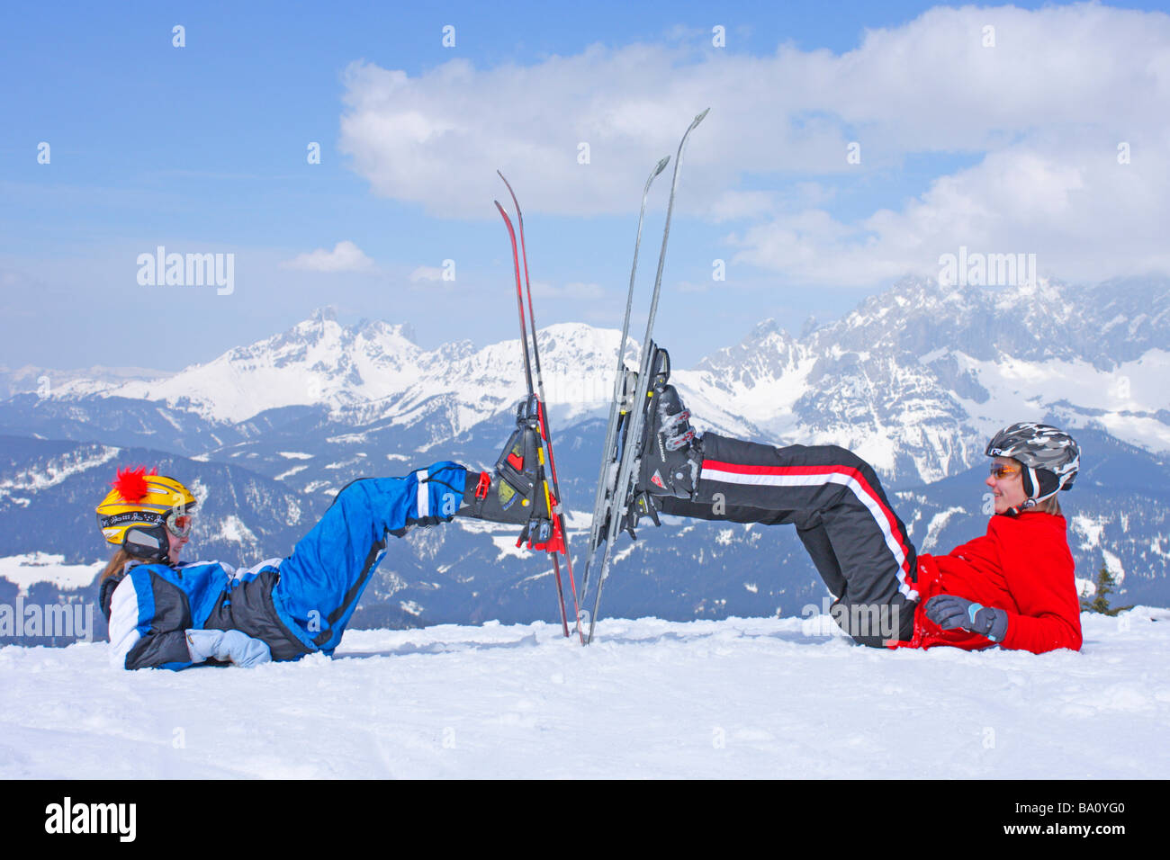 brother and sister posing with their skis on Reiteralm in Styria, in the background Dachstein Mountain, Austria Stock Photo