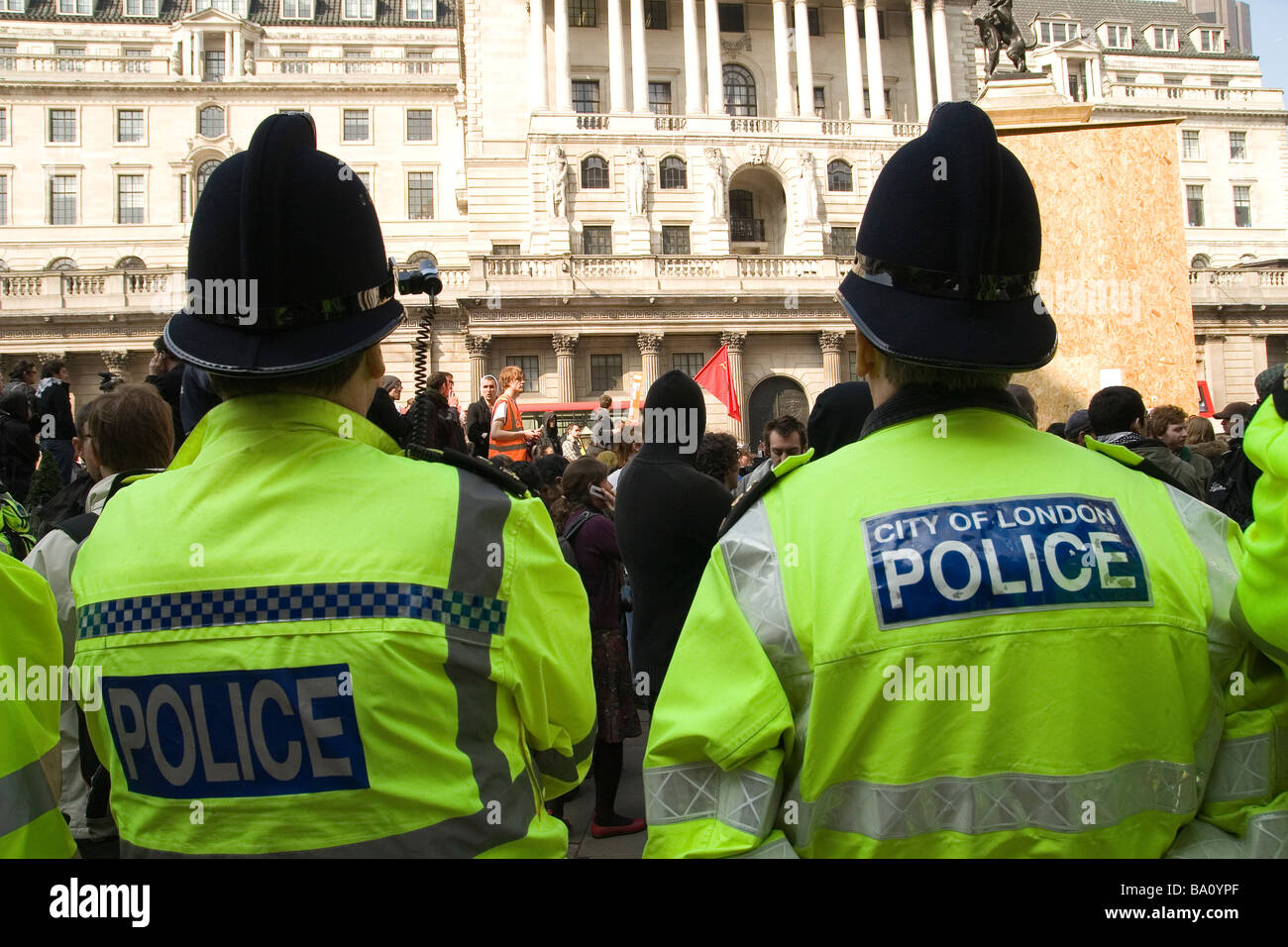 City of London police officers watch protesters at the Bank of England in London Stock Photo