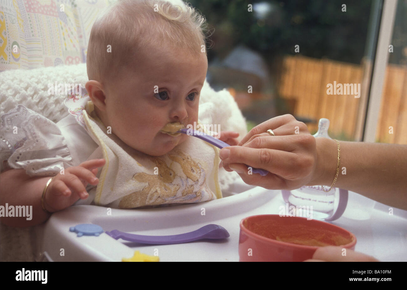 baby with down s syndrome being spoon fed Stock Photo Alamy
