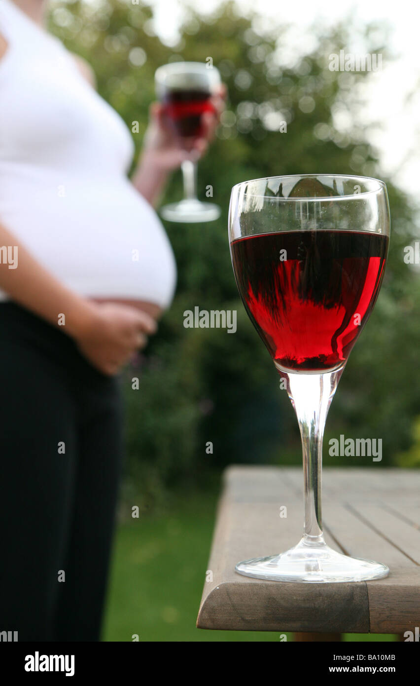 A glass of wine with a pregnant woman in the background Stock Photo Alamy