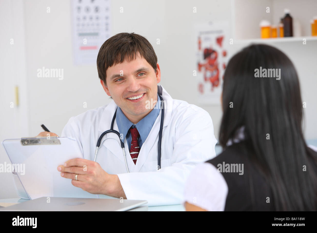 Doctor at desk consulting with patient Stock Photo