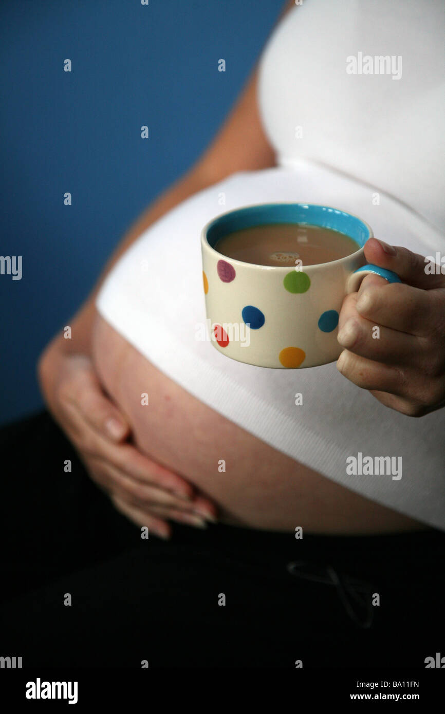 A pregnant woman with a cup of coffee Stock Photo - Alamy
