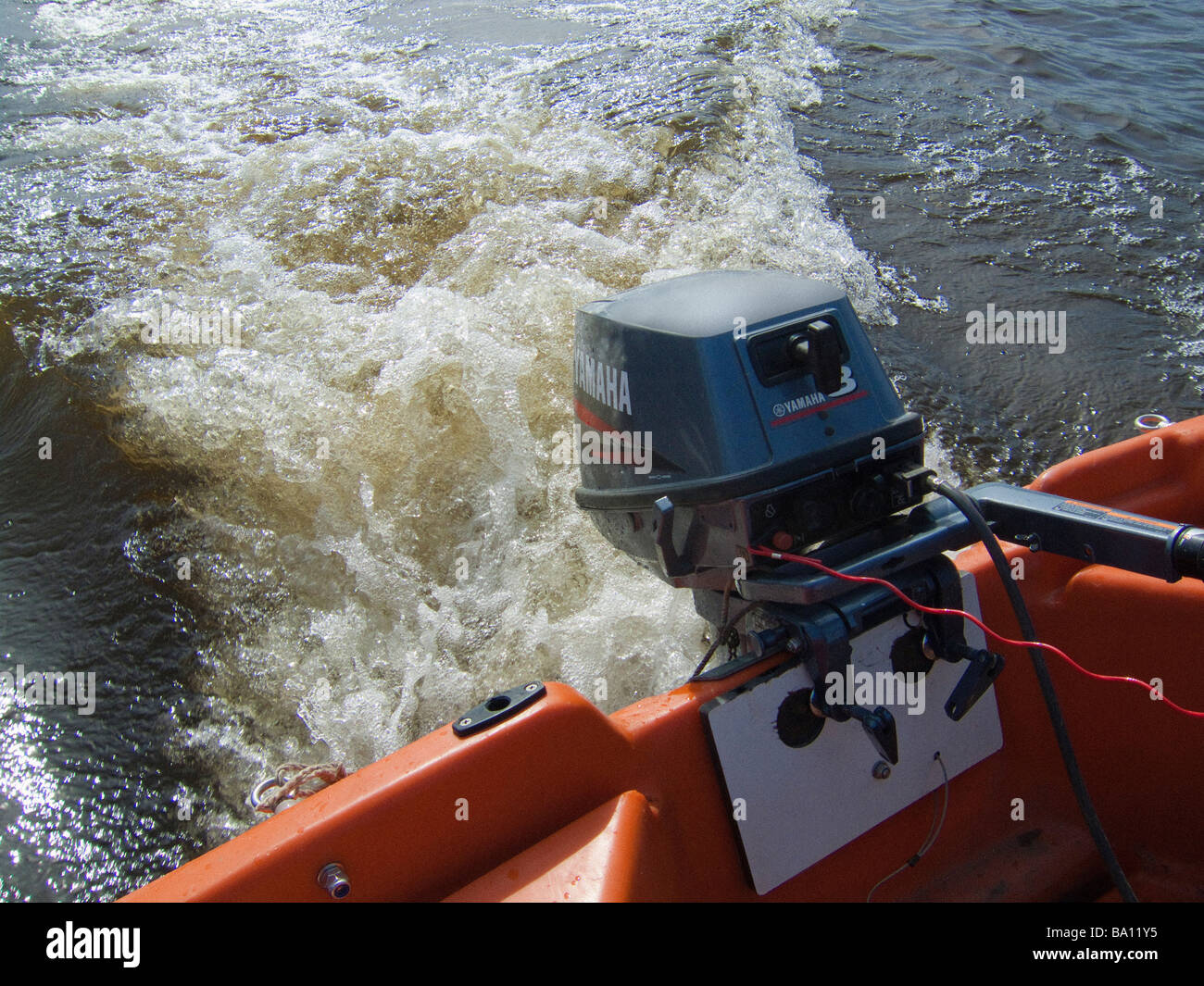 Outboard motor on speedboat showing wash which causes damage to riverbanks Stock Photo