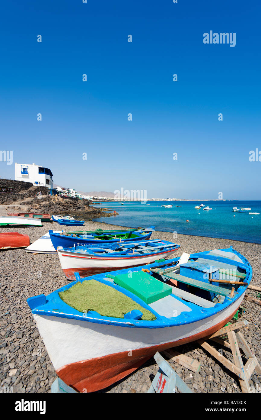 Fishing boats on a pebble beach in the port area, Playa Blanca, Lanzarote, Canary Islands, Spain Stock Photo