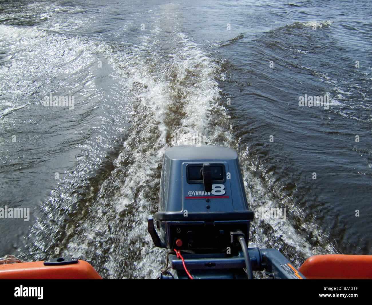 Outboard motor engine on speedboat showing wash which causes damage to riverbank Stock Photo