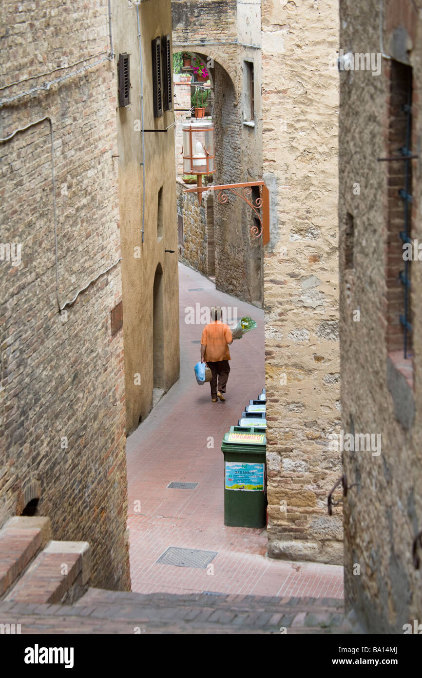 Local resident on the way home after visiting the market in the Piazza del Doumo, San Gimignano, Tuscany, Italy. Stock Photo