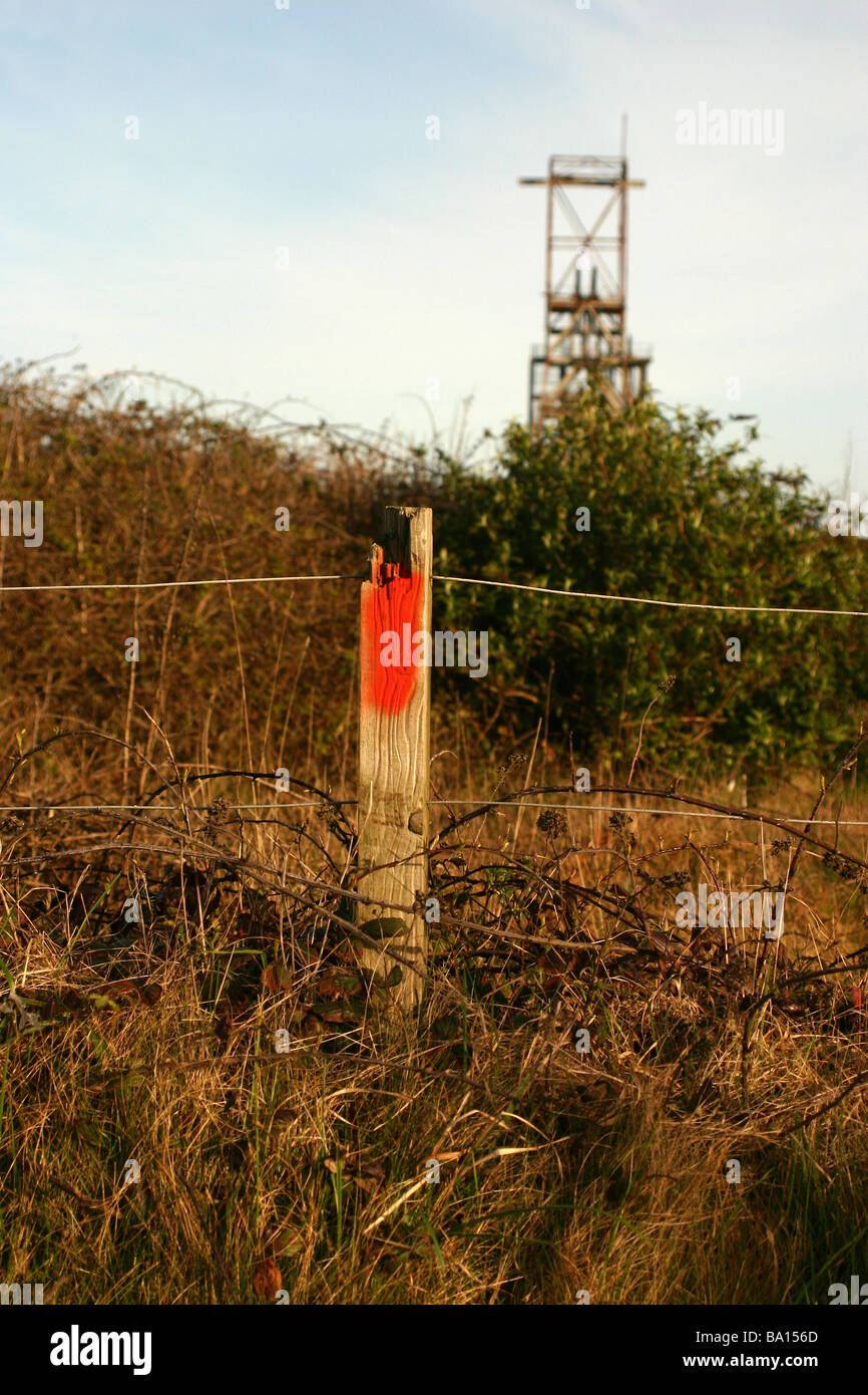 Red marker post with South Crofty Tinmine headgear in background  Pool Cornwall UK Stock Photo