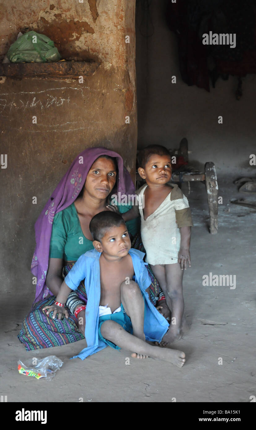 Mother and children from the Garasia Tribe in their home in a village in Gujarat, India Stock Photo