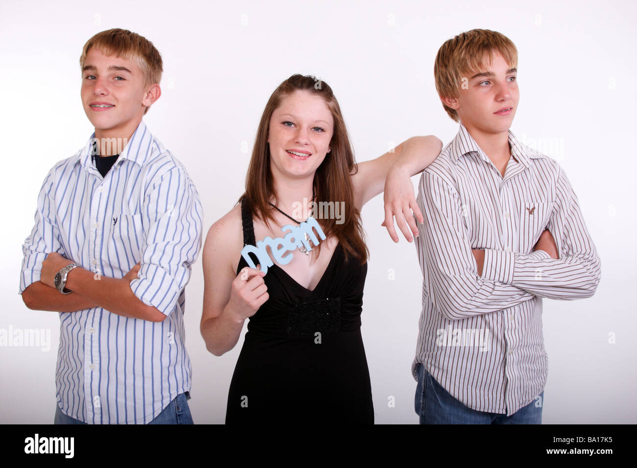 A Teen Girl Holding Onto The Word Dream With Twin Teen Boys On Either Side Stock Photo Alamy