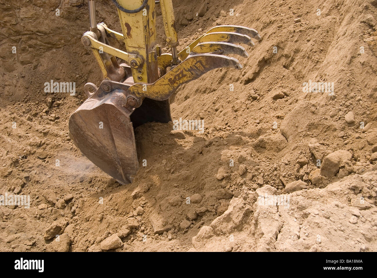 Track mounted excavator removing rock from excavation as part of an