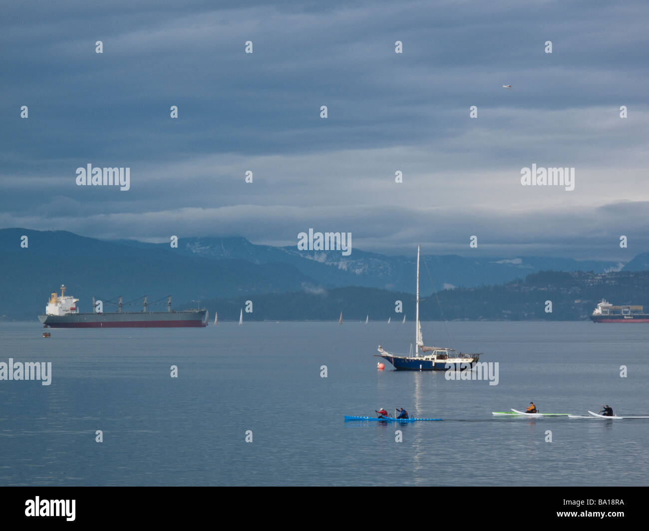 Kayakers sailboat container ship in English Bay Vancouver British Columbia Stock Photo
