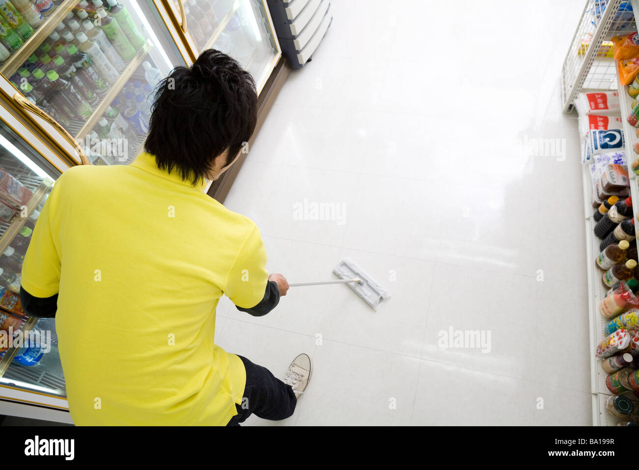 Convenience store clerk cleaning up store Stock Photo Alamy