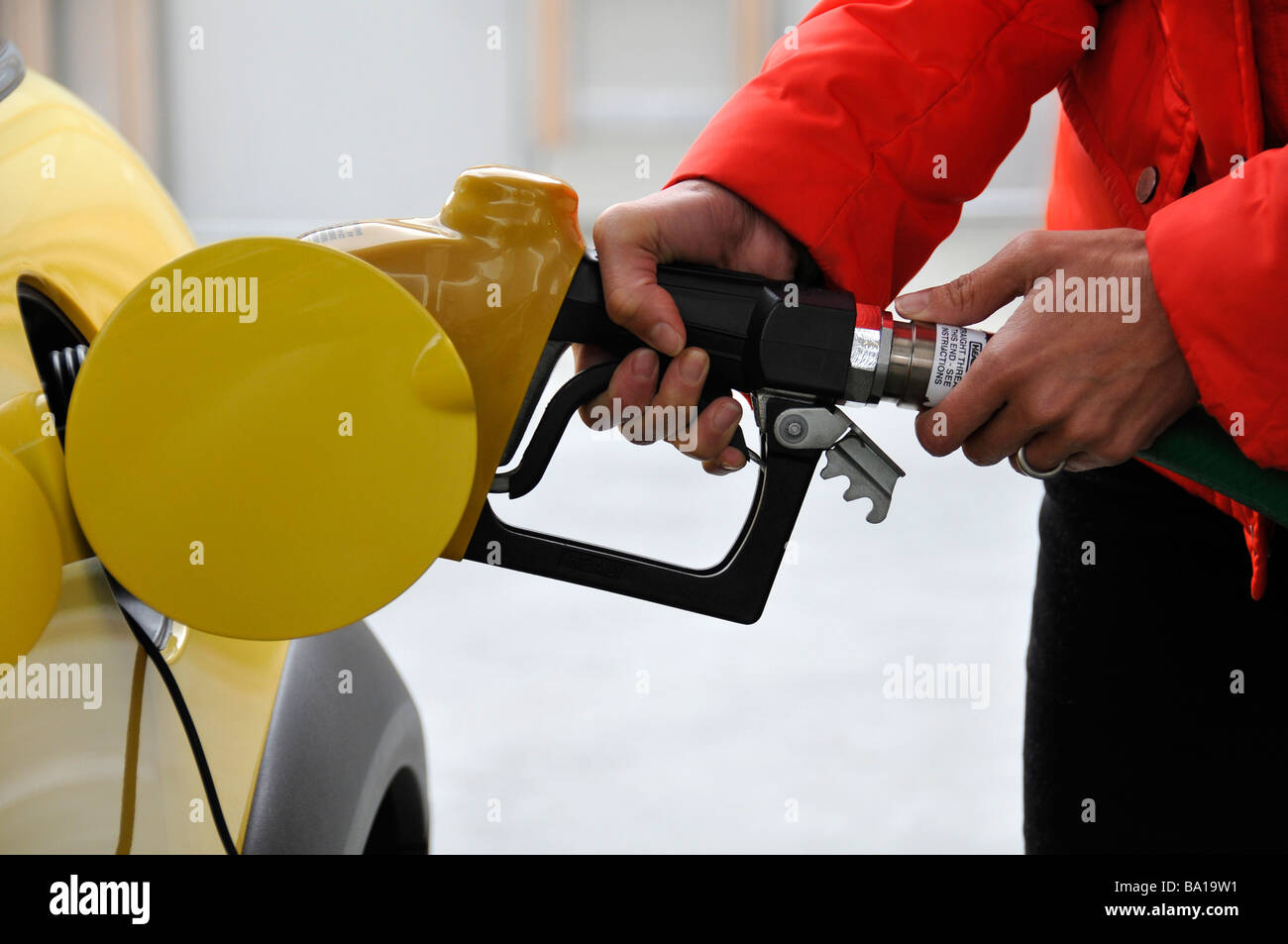Woman pumping gas into her car Stock Photo