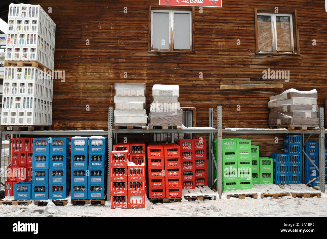 Crates of empty beer and drink bottles out side a snowy bar in the Swiss Alps Stock Photo