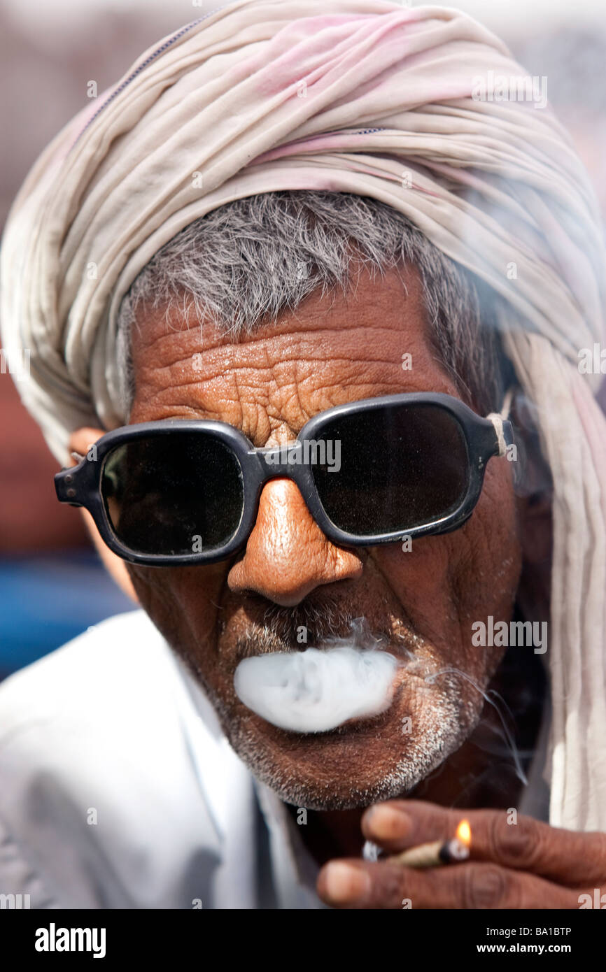 An Indian man smokes a Bidi cigarette at a political rally for BSP candidate Kumari Mayawati at Palwal Haryana State India Stock Photo